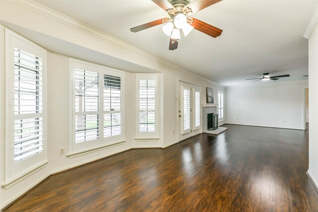 unfurnished living room with ceiling fan, dark wood-type flooring, and crown molding