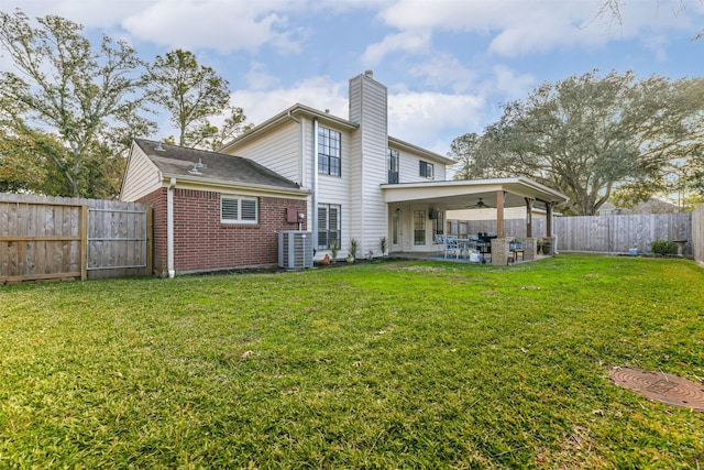 back of property with ceiling fan, central AC, a yard, and a patio