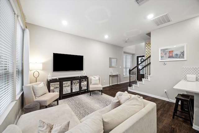 living room featuring dark wood-type flooring and plenty of natural light