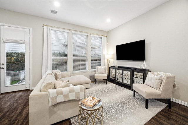 living room featuring plenty of natural light and dark wood-type flooring