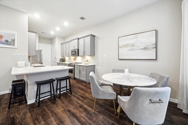 dining space with sink and dark wood-type flooring