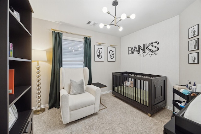 carpeted bedroom with a notable chandelier and a crib