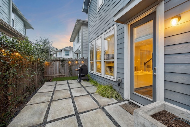 patio terrace at dusk featuring grilling area