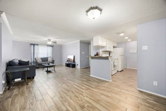 kitchen with kitchen peninsula, ceiling fan, white refrigerator, light wood-type flooring, and white cabinetry