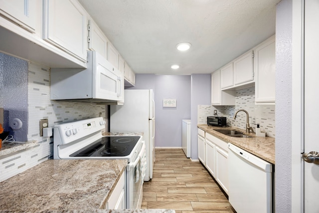 kitchen featuring sink, white cabinetry, white appliances, and decorative backsplash