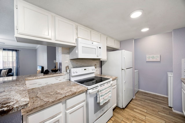 kitchen featuring backsplash, white cabinetry, light stone countertops, white appliances, and separate washer and dryer