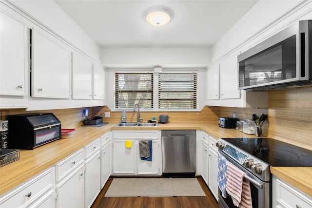 kitchen featuring dark wood-type flooring, sink, white cabinets, and appliances with stainless steel finishes