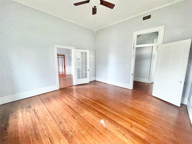 unfurnished bedroom with hardwood / wood-style flooring, ceiling fan, a closet, and french doors