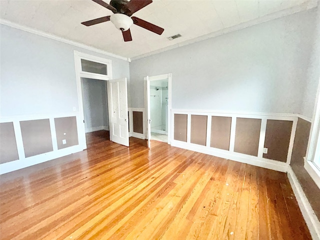 empty room featuring hardwood / wood-style flooring, ceiling fan, and ornamental molding