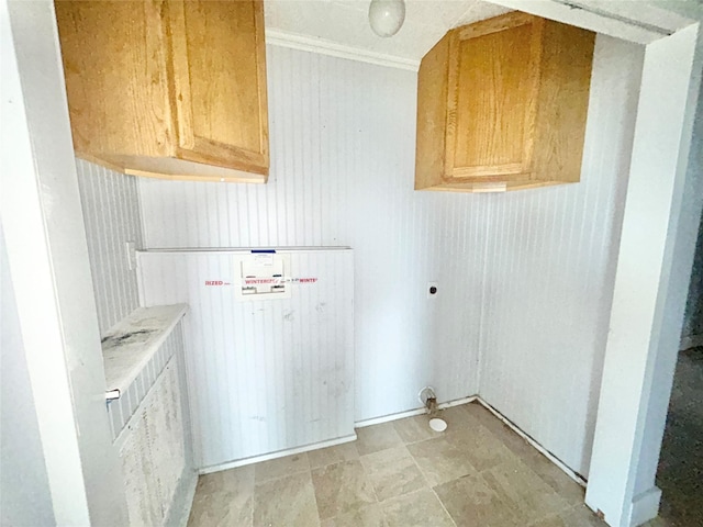 clothes washing area with electric dryer hookup, ornamental molding, and cabinets