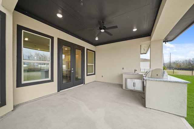 view of patio / terrace with sink, exterior kitchen, ceiling fan, and french doors