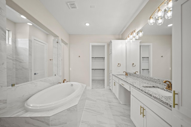 bathroom featuring vanity and tiled tub