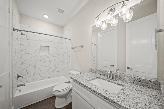 full bathroom with toilet, vanity, and tiled shower / bath