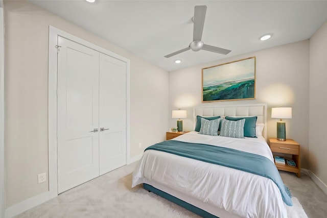 bedroom featuring a closet, ceiling fan, and light colored carpet