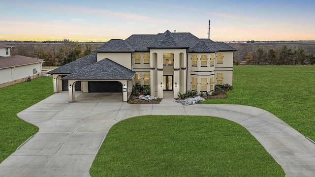 french country home featuring a garage and a yard