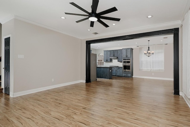 unfurnished living room featuring ornamental molding, ceiling fan with notable chandelier, and light hardwood / wood-style flooring