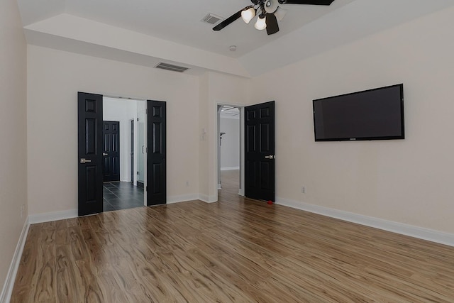 unfurnished bedroom featuring ceiling fan, hardwood / wood-style flooring, and lofted ceiling