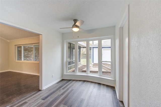 unfurnished room with hardwood / wood-style flooring, a textured ceiling, ornamental molding, and ceiling fan