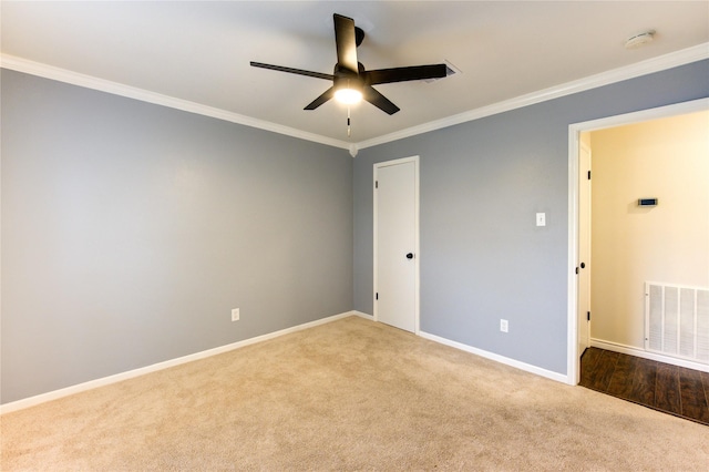 carpeted empty room featuring ceiling fan and crown molding