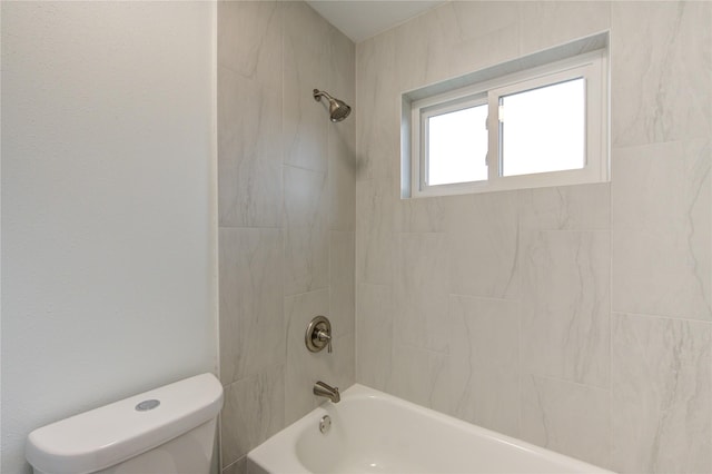 bathroom with toilet and tiled shower / bath