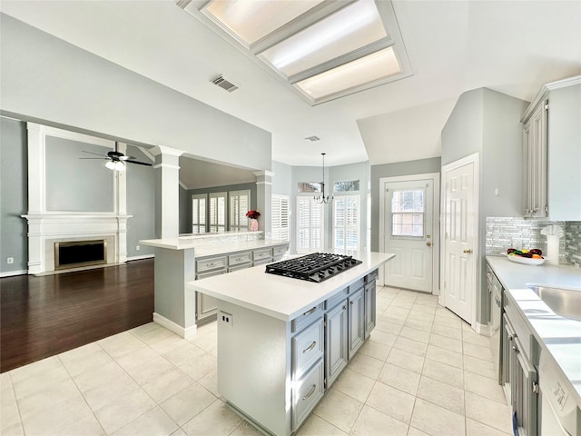 kitchen with a center island, pendant lighting, light countertops, appliances with stainless steel finishes, and open floor plan