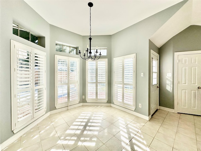 unfurnished dining area with a healthy amount of sunlight, light tile patterned floors, and a chandelier