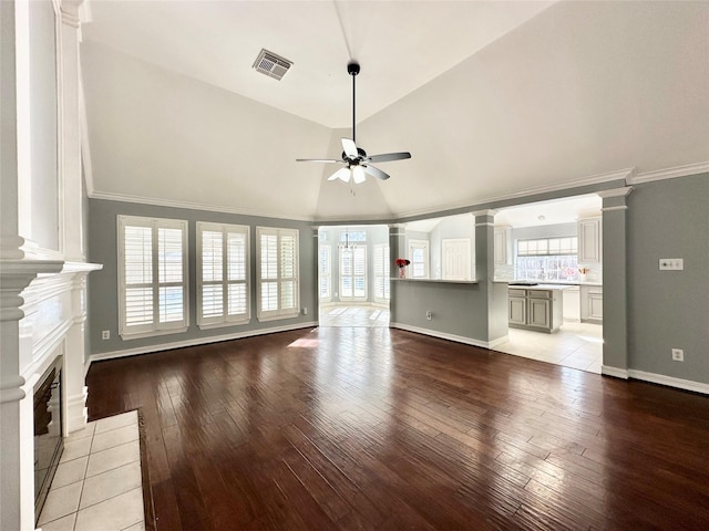 unfurnished living room with lofted ceiling, ceiling fan, wood finished floors, and visible vents