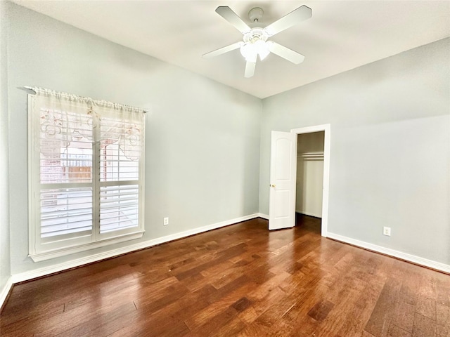 unfurnished bedroom with dark wood-style floors, a closet, a ceiling fan, and baseboards