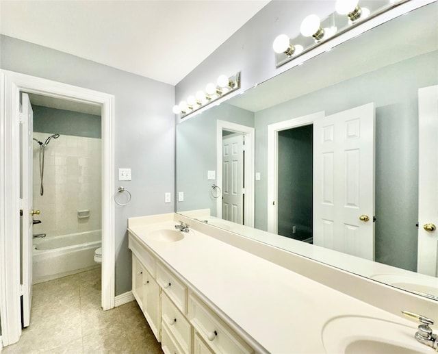 bathroom with double vanity, shower / bathing tub combination, a sink, and toilet