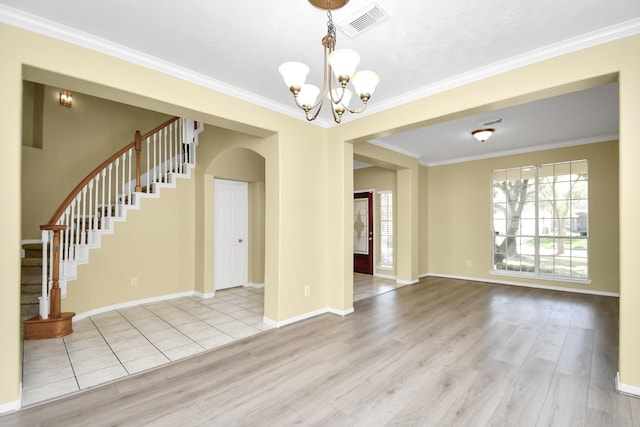 interior space featuring an inviting chandelier, light hardwood / wood-style flooring, and ornamental molding