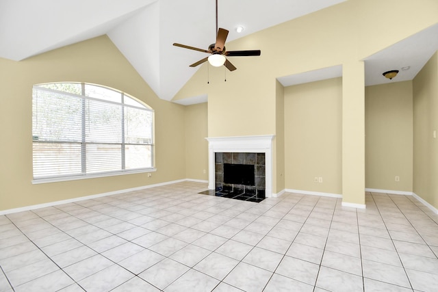 unfurnished living room with ceiling fan, a tiled fireplace, lofted ceiling, and light tile patterned flooring