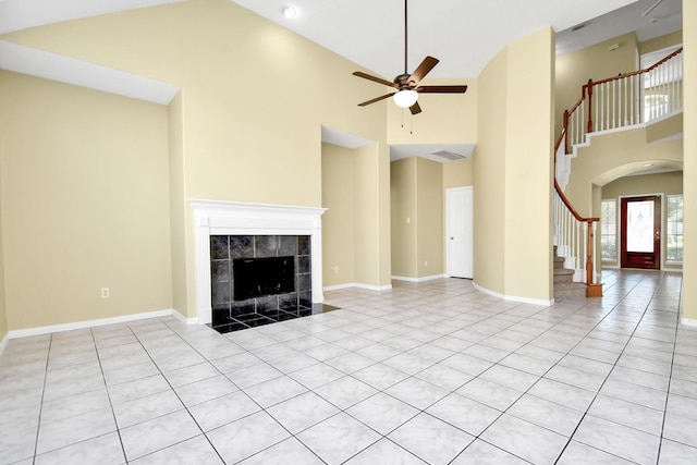 unfurnished living room with high vaulted ceiling, a tile fireplace, ceiling fan, and light tile patterned flooring