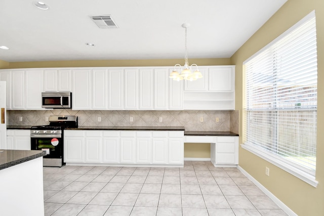 kitchen featuring decorative light fixtures, white cabinetry, light tile patterned floors, and appliances with stainless steel finishes