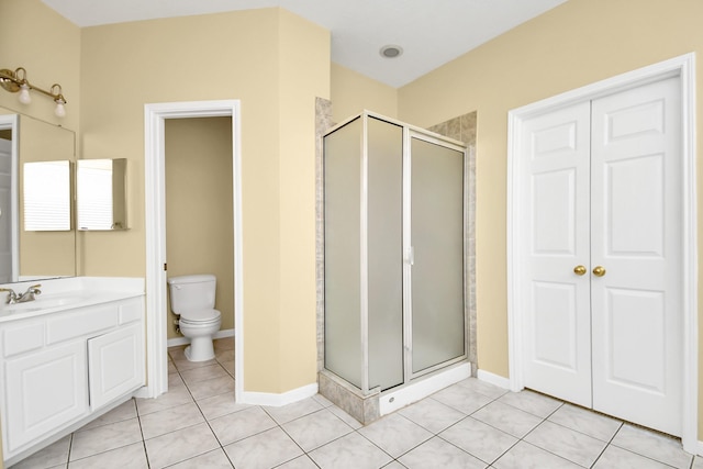 bathroom with toilet, a shower with door, vanity, and tile patterned flooring