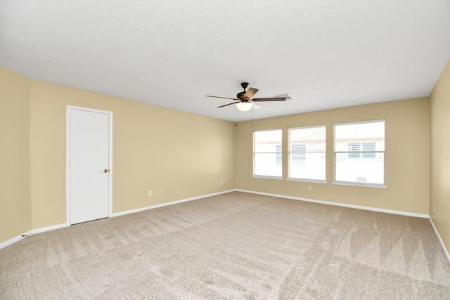 empty room featuring ceiling fan and light carpet