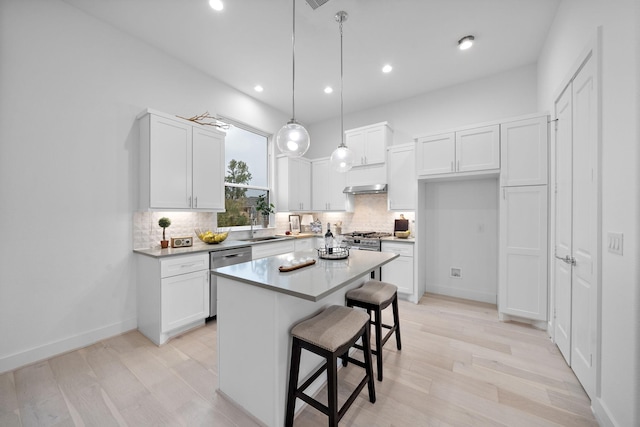 kitchen with white cabinets, stainless steel appliances, a center island, and hanging light fixtures