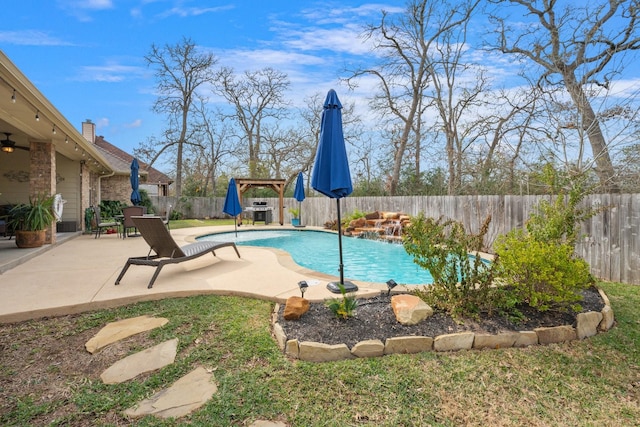 view of swimming pool featuring ceiling fan, a fenced backyard, a fenced in pool, and a patio