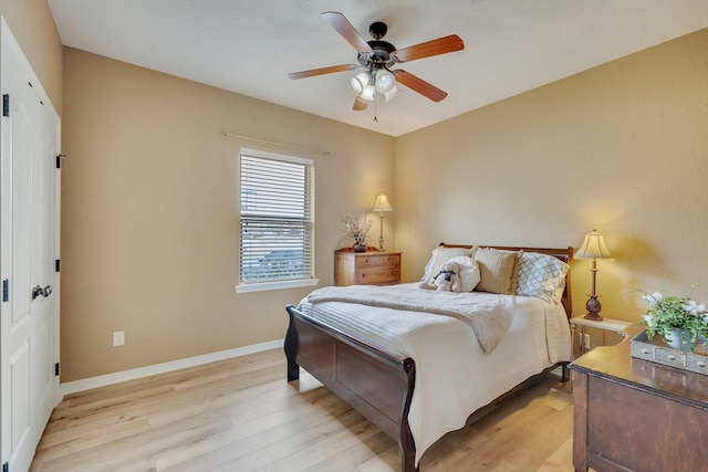 bedroom featuring baseboards, a ceiling fan, and light wood finished floors