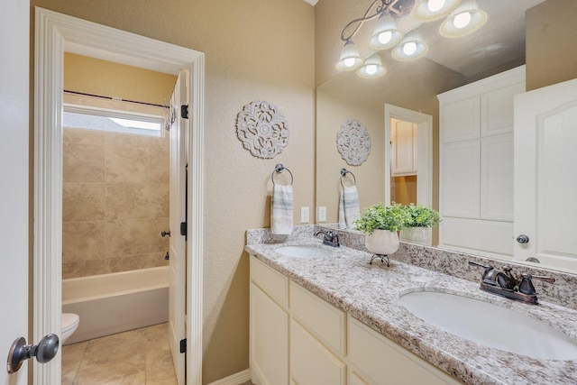 full bath with toilet, tile patterned floors, a sink, and double vanity