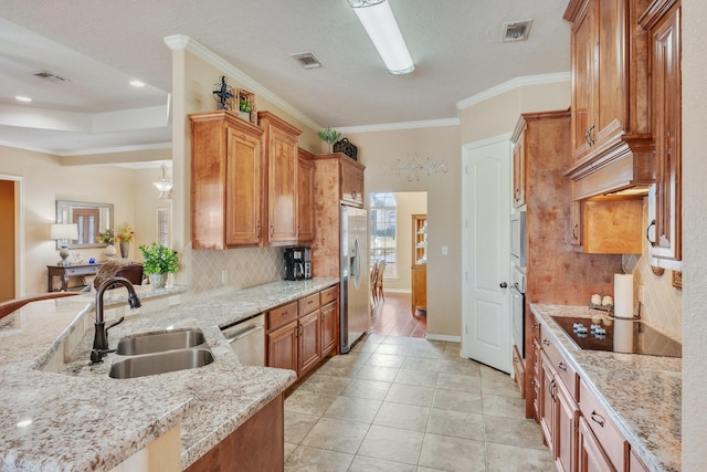 kitchen with decorative backsplash, stainless steel appliances, visible vents, and a sink