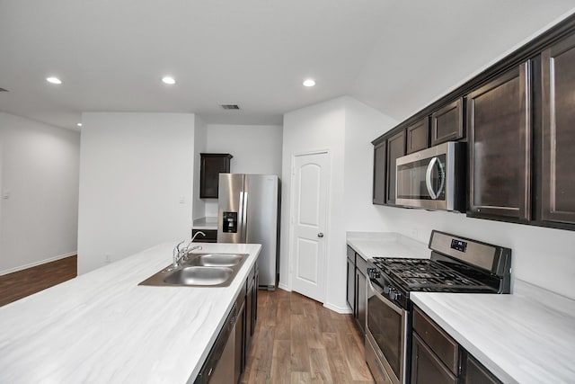 kitchen featuring sink, dark brown cabinets, dark hardwood / wood-style floors, and stainless steel appliances