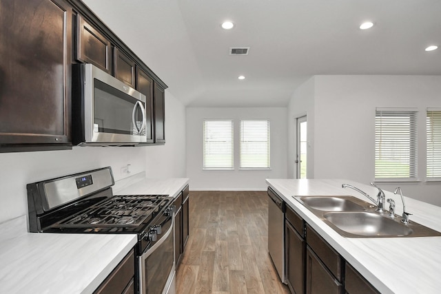 kitchen with sink, stainless steel appliances, dark brown cabinets, and light hardwood / wood-style floors