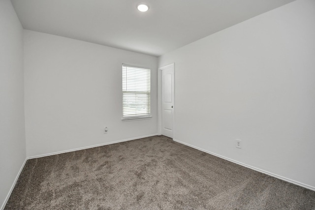 empty room featuring dark colored carpet