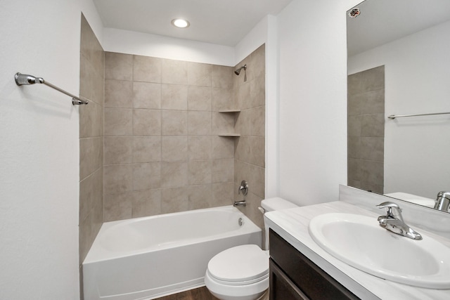 full bathroom featuring toilet, tiled shower / bath, and vanity