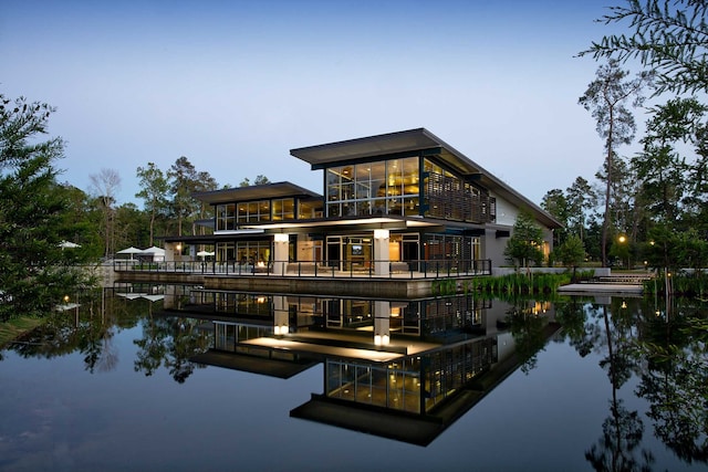 back house at dusk with a water view