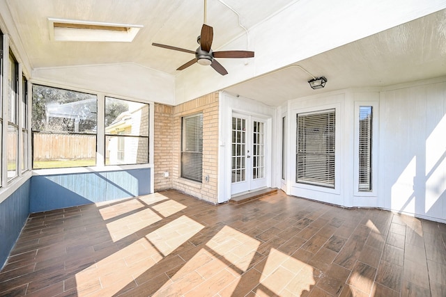 unfurnished sunroom with vaulted ceiling with skylight and ceiling fan