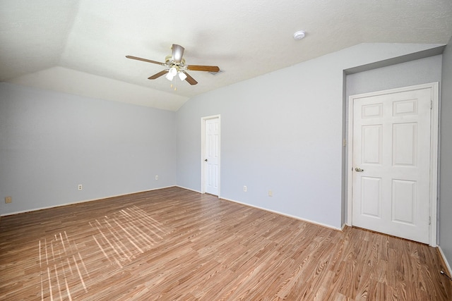 unfurnished room with ceiling fan, light hardwood / wood-style floors, and lofted ceiling