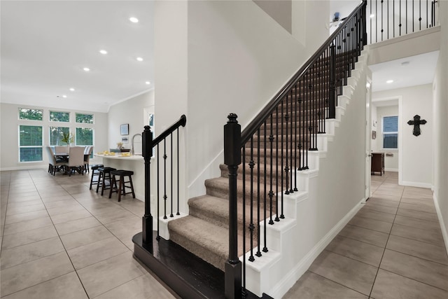 stairs featuring ornamental molding and tile patterned floors