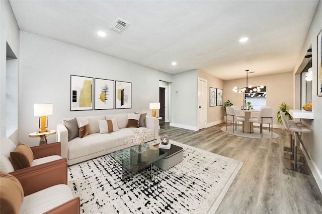 living room with hardwood / wood-style flooring and an inviting chandelier