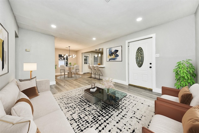 living room featuring an inviting chandelier and light hardwood / wood-style flooring